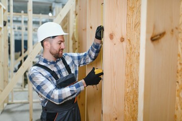 Worker carpenter assembling a modular house