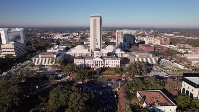 Florida capitol building in downtown capital city tower in Tallahassee, FL with various government and political buildings and historic structure in front of skyscraper in cityscape