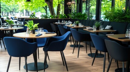 Obraz premium Modern dining area featuring elegant tables and blue chairs surrounded by greenery in a vibrant location