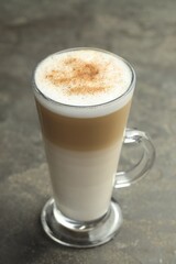 Tasty latte macchiato in glass cup on grey table, closeup