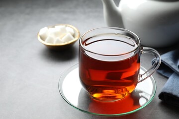 Refreshing black tea in cup on grey table, closeup. Space for text