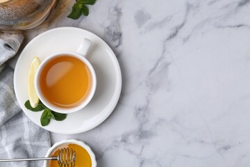 Aromatic mint, fresh leaves, lemon and honey on light marble table, flat lay. Space for text