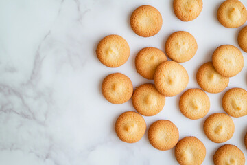 Homemade buttery cookies arranged on a marble surface showcasing their golden brown color and round shape