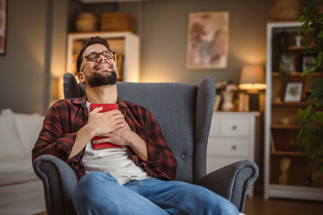 adult man book lover sit in the armchair and read enthusiastically