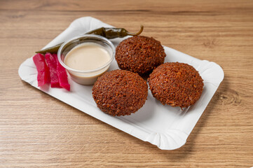 tray with Lebanese falafel on light-colored wooden table typical Middle Eastern dish consisting of spiced and fried legume balls