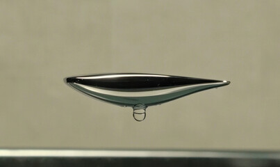 Fototapeta premium Captivating Image of a Metallic Liquid Droplet Suspended in Mid-Air Showcasing Stunning Reflection and Balance in a Scientific Experiment