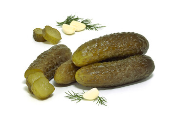 Ogórki kiszone, w całości i pokrojone obok czosnku i koperku na białym tle