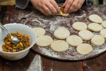 Hands of a Jewish woman form triangular gomentashi with a sweet filling