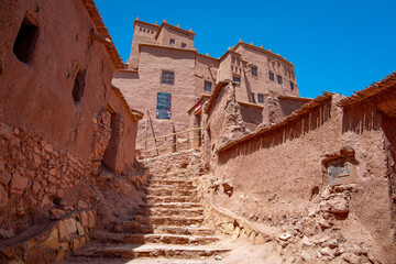 Staircase leading up to traditional red clay buildings in Ait Benhaddou Kasbah, a UNESCO World Heritage site in Ouarzazate, Morocco, highlighting ancient architecture and cultural heritage