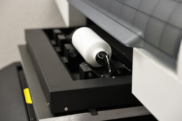 Modern printer and bottle with carabiner indoors, closeup