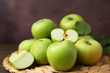 Whole and cut green apples on table, closeup