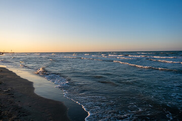 dawn on the beach of Cesenatico with sun and gentle waves. High quality photo