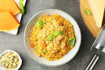 Delicious pumpkin risotto on grey table, flat lay