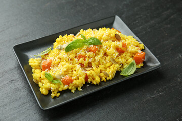 Delicious pumpkin risotto on black table, closeup