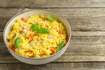 Delicious pumpkin risotto in bowl on wooden table, closeup. Space for text
