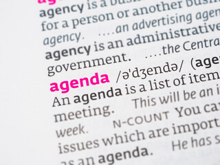 The word "agenda" against the background of an open vocabulary, symbolizing plans and tasks in a business and personal context.
