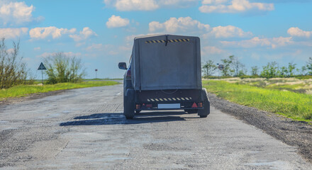 SUV with a trailer moves along a country road