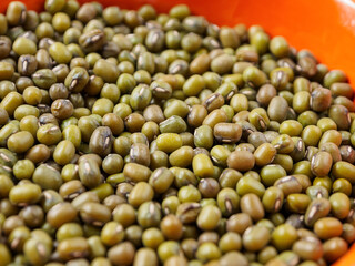 Mung beans on a light background, emphasizing their shape and texture, create a feeling of freshness and naturalness.