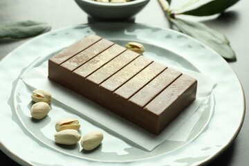 Tasty Dubai chocolate with pistachios and knafeh on grey table, closeup