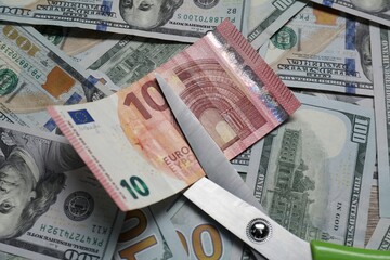 Different banknotes and scissors as background, top view