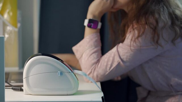 woman sits at a desk in her home office, using a thermal shipping barcode label printer to print labels.