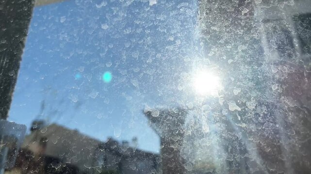 Dusty and dirty window with visible smudges and streaks, illuminated by sunlight, emphasizing lack of cleanliness and hygiene.