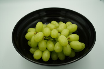 Fresh green grapes nestled in a black bowl ready to be enjoyed as a healthy snack or dessert treat