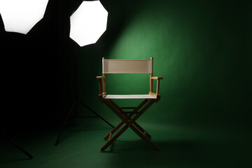 Photo studio with green screen background and wooden stool against professional lighting equipment....