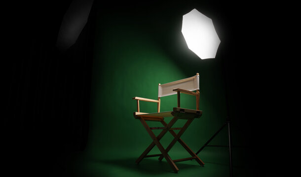 Photo studio with green screen background and wooden stool against professional lighting equipment. Interior of photo studio with professional lighting equipment and director chair with green backdrop