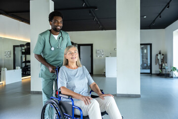 Female patient in wheelchair with doctor in rehab center receiving physiotherapy assistance