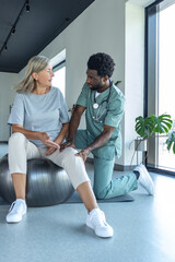 Orthopedic specialist helping patient with knee flexion exercises focusing on joint recovery