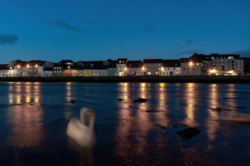 The Long Walk and River Corrib captured in a long exposure, with swans gliding smoothly.