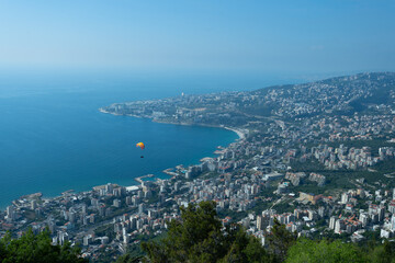 A breathtaking aerial view of Jounieh&rsquo;s seaside with resorts, boats, and paragliders over the blue Mediterranean. Travel blogs, brochures, and adventure magazines.