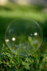 Pękająca bańka mydlana na zielonym, rozmytym tle