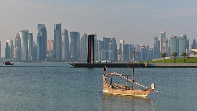 Wooden tour ships at seaside in Doha Qatar and cityscape with skyscrapers in the background