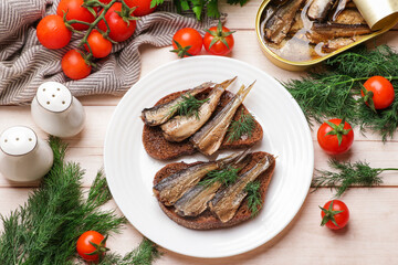 Delicious sandwiches with sprats and dill served on white wooden table, top view