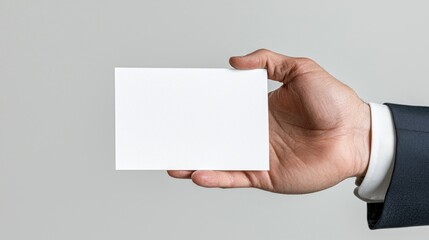 Obraz premium Hand holding blank card, grey background, business presentation