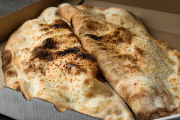 Delicious calzones in cardboard box on table, closeup