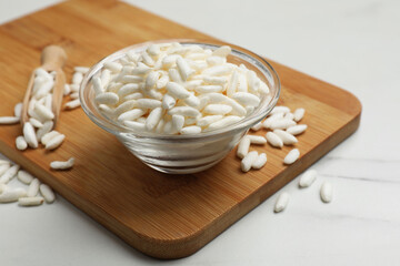 Puffed rice in bowl on white marble table, closeup