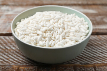 Puffed rice in bowl on wooden table, closeup