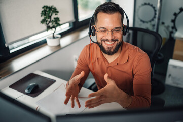 Smiling businessman having video call and gesturing during online meeting