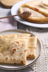 Delicious folded crepes on table, closeup view
