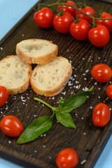 Slices of fresh bread with butter resting on a dark wooden board.