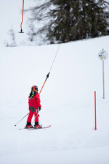 skier being pulled up the hill by a T-bar lift