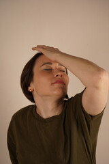 Young Asian girl standing over gray background suffering from headache, despair and stressed pain...