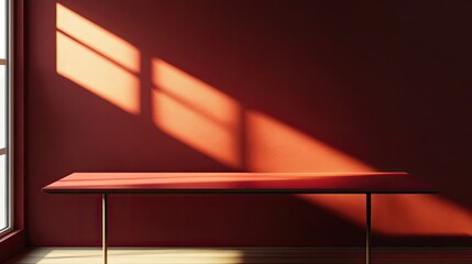 Obraz premium Empty red table in sunlit room with window shadows. Use for product display or interior design