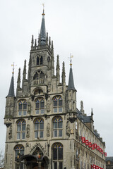 Fototapeta premium Front view of the Gouda town hall with a cloudy sky in the background. The town hall was built in the fifteenth-century and is one of the oldest Gothic town halls in the Netherlands. 