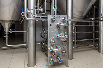 Industrial brewery equipment with stainless steel fittings and large tanks