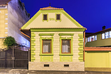 A small house with a green roof and yellow trim