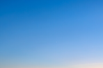 Clear blue sky with small airplane in the distance
